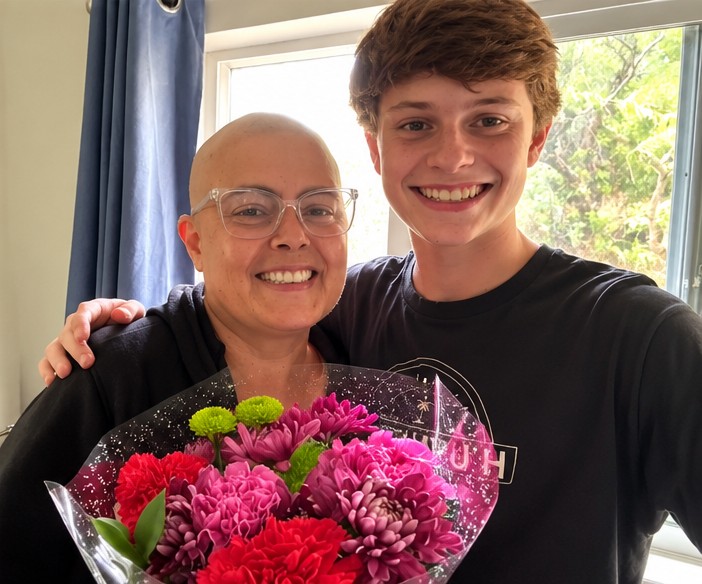 Angie and her son holding a colorful bouquet of flowers